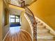 Beautiful curved staircase with wood railing and carpeted steps in the foyer at 8461 Pawnee Ln, Niwot, CO 80503