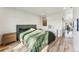 Bright bedroom with light wood floors, gray upholstered bed frame, and an ensuite door at 4129 Zenobia St, Denver, CO 80212