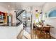 Open-concept living space with a modern kitchen, dining area, and a sleek staircase at 4129 Zenobia St, Denver, CO 80212