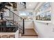 Interior staircase with black metal railing, carpeted steps, and street view windows at 4129 Zenobia St, Denver, CO 80212