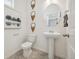 Compact powder room featuring a pedestal sink, decorative accents, and a neutral color palette at 9865 Biscay St, Commerce City, CO 80022