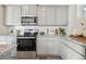 Well-equipped kitchen featuring granite countertops, stainless steel appliances, and gray cabinets at 9865 Biscay St, Commerce City, CO 80022