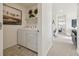 Convenient laundry room with modern washer and dryer, plus extra shelving at 9865 Biscay St, Commerce City, CO 80022