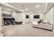 Spacious basement featuring carpeted floors, a large sofa, and multiple TVs at 1495 W 137Th Ave, Broomfield, CO 80023