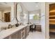 Bathroom vanity with double sinks, makeup vanity, mirrors, and tile accent wall at 1495 W 137Th Ave, Broomfield, CO 80023