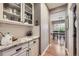 Butler's pantry with marble countertops, custom cabinetry, and access to the dining room at 1495 W 137Th Ave, Broomfield, CO 80023