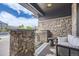 Comfortable front porch with stone columns, outdoor seating, and neutral colors at 1495 W 137Th Ave, Broomfield, CO 80023