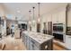 Open-concept kitchen with a large center island featuring pendant lighting and stainless steel appliances at 1495 W 137Th Ave, Broomfield, CO 80023