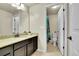Well-lit bathroom features a granite countertop, dark cabinetry, and a shower with colorful curtain at 6829 Juniper Ct, Frederick, CO 80530