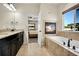 Bathroom featuring a large soaking tub, fireplace, and granite countertops at 6829 Juniper Ct, Frederick, CO 80530