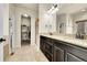 Well-lit bathroom with dual sinks, granite countertops, and a walk-in shower at 6829 Juniper Ct, Frederick, CO 80530