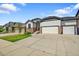Ranch home with a three-car garage, stone accents, and a well-manicured front lawn and concrete driveway at 6829 Juniper Ct, Frederick, CO 80530