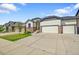 Attractive home showcasing a three-car garage, stone accents, and lush green lawn at 6829 Juniper Ct, Frederick, CO 80530