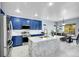 Stylish kitchen featuring blue cabinets, a marble island, and an adjoining dining area at 6829 Juniper Ct, Frederick, CO 80530