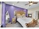 Main bedroom with a luxurious bed frame, a fireplace, and tray ceiling at 6829 Juniper Ct, Frederick, CO 80530