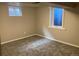 A simple bedroom with neutral carpet and two windows to provide natural light at 2101 S Lowell Blvd, Denver, CO 80219
