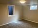 A finished bedroom in the basement with neutral carpet and two windows to provide natural light at 2101 S Lowell Blvd, Denver, CO 80219