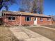 Charming red brick home with well-maintained lawn, a welcoming entrance, and a spacious driveway at 2101 S Lowell Blvd, Denver, CO 80219