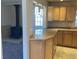 Eat in kitchen with light wood cabinets and adjacent living area with fireplace at 2101 S Lowell Blvd, Denver, CO 80219