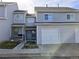 Townhome exterior with a two car garage, sidewalk, and a manicured lawn at 3849 E 121St Ave, Thornton, CO 80241