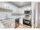 White kitchen with stainless steel appliances, modern finishes, and ample cabinet space at 3849 E 121St Ave, Thornton, CO 80241