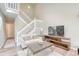 Inviting living room with staircase, features a modern television, and natural light at 3849 E 121St Ave, Thornton, CO 80241