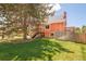 Large grassy backyard with mature tree and fence, offering shade and privacy at 19595 Mitchell Dr, Denver, CO 80249