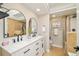 Elegant bathroom featuring dual sinks, modern fixtures, and a separate shower area with neutral tile at 19595 Mitchell Dr, Denver, CO 80249