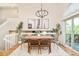 Bright dining room with a high ceiling, modern chandelier, and access to a deck at 19595 Mitchell Dr, Denver, CO 80249