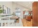 Open-concept dining area with stylish lighting, hardwood floors, and a view into the modern kitchen at 19595 Mitchell Dr, Denver, CO 80249