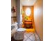 Charming powder room features unique oval window, decorative accents, and tile flooring at 10218 Woodrose Ct, Highlands Ranch, CO 80129