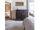 Spacious bedroom with a large dresser, carpet floors, and access to the bathroom at 10218 Woodrose Ct, Highlands Ranch, CO 80129
