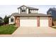 Inviting home exterior featuring a three-car garage and well-manicured lawn at 10218 Woodrose Ct, Highlands Ranch, CO 80129