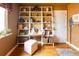 Bright home office with hardwood floors, custom shelving, and comfortable workspace at 10218 Woodrose Ct, Highlands Ranch, CO 80129