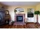 Inviting living room boasts brick fireplace, built-in shelving, and beautiful hardwood floors at 10218 Woodrose Ct, Highlands Ranch, CO 80129