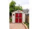 Charming outdoor shed with red doors and a brick-paved walkway at 10218 Woodrose Ct, Highlands Ranch, CO 80129