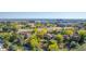Aerial view showcasing townhouses surrounded by mature trees with a view of the city skyline in the distance at 119 Ward Ct, Lakewood, CO 80228