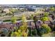 Aerial view of the home and surrounding neighborhood showcasing lush trees and city skyline in the distance at 119 Ward Ct, Lakewood, CO 80228