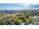 Aerial view of community featuring pond, landscaping, mature trees and city skyline in the background at 119 Ward Ct, Lakewood, CO 80228