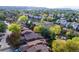 Aerial view of the property with a pond, and surrounding neighborhood with mature colorful trees at 119 Ward Ct, Lakewood, CO 80228