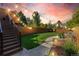 Lush backyard features a well-maintained lawn, stylish string lights, and a paved walkway, ideal for entertaining and relaxation at 119 Ward Ct, Lakewood, CO 80228