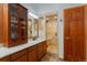 Detailed bathroom with a glass shower, tile flooring, a sink with granite countertop, and wood door at 119 Ward Ct, Lakewood, CO 80228