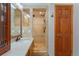 Detailed bathroom with a glass shower, tile flooring, a sink with granite countertop, and wood door at 119 Ward Ct, Lakewood, CO 80228