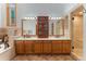 Primary bathroom with a double vanity, wood cabinets, and a glass shower with tile surround at 119 Ward Ct, Lakewood, CO 80228