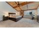 Spacious main bedroom with wood ceiling beams and a seating area with an exercise bike at 119 Ward Ct, Lakewood, CO 80228