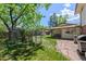 Fenced backyard with lush grass and a covered patio at 1844 S Pontiac Way, Denver, CO 80224