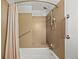Bathroom with a shower and bathtub combination, shower curtain, and safety grab bar at 1844 S Pontiac Way, Denver, CO 80224