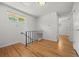 Bright hallway with hardwood floors, black railing and a window showcasing the outdoor greenery at 1844 S Pontiac Way, Denver, CO 80224