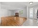 Bright living room featuring hardwood floors, a brick fireplace, and ample natural light at 1844 S Pontiac Way, Denver, CO 80224