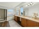 Bright bathroom with a bathtub, glass shower, double vanity, and wood cabinets at 1983 Candleglow St, Castle Rock, CO 80109